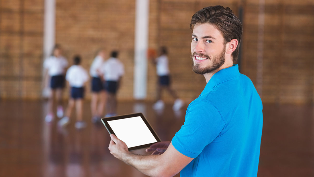 Sportlehrer mit Tablet in der Hand