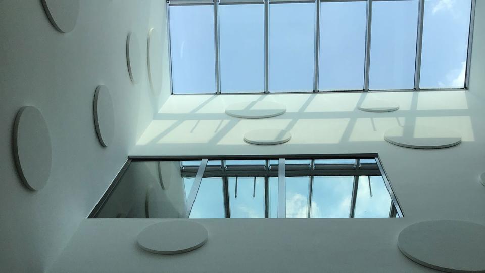 Blick an einer Wand entlang zu einem Glasdach
