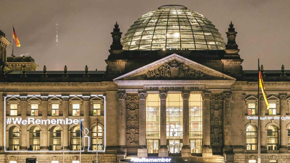 Deutscher Bundestag beleuchtet mit der Schrift "#We remember"