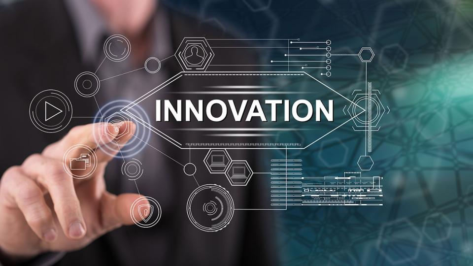 Ein Mann berührt eine Glasplatte, auf der das Wort Innovation abgebildet ist