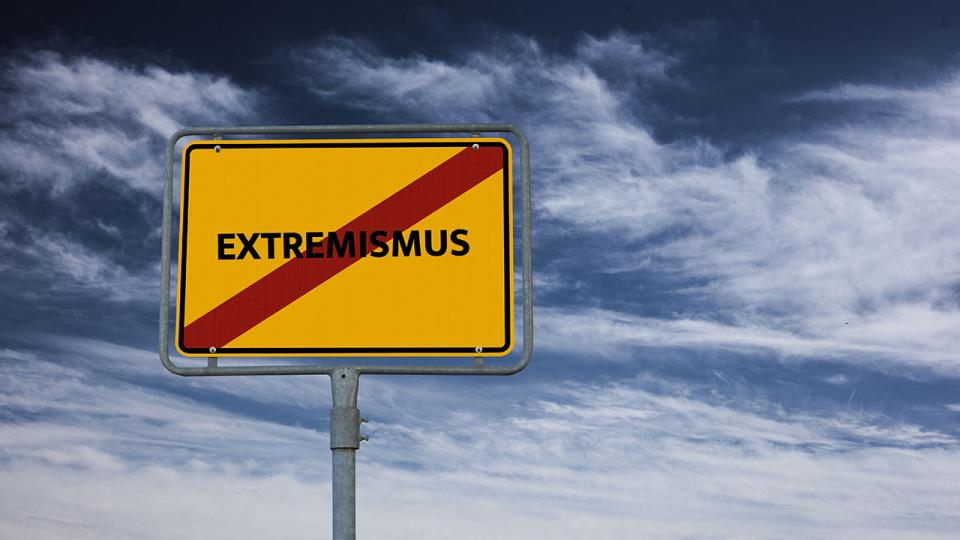 Ortsausgangsschild mit Schriftzug Extremismus