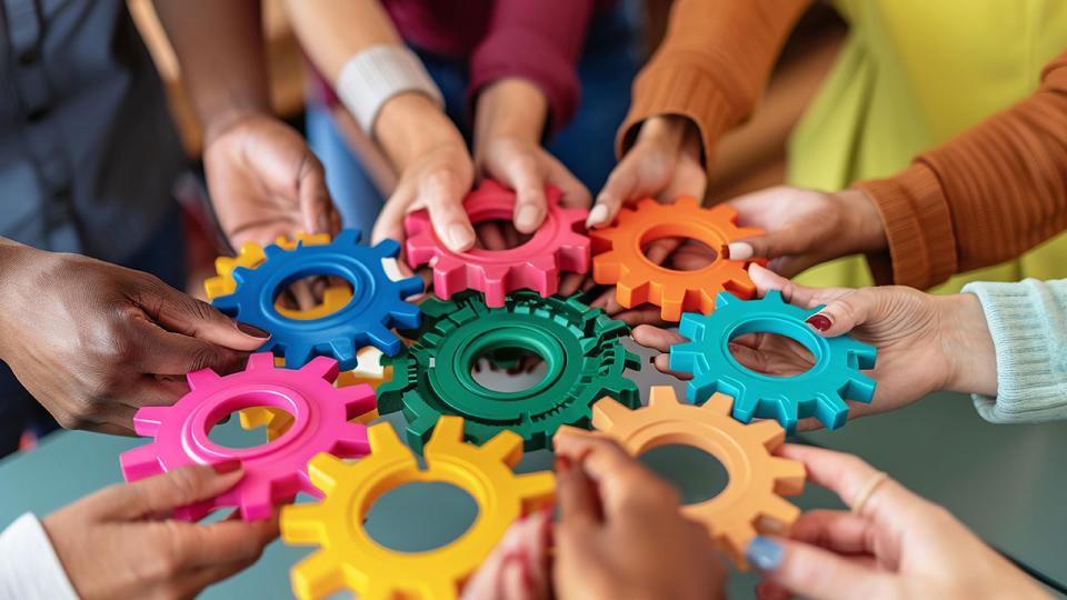 Verschiedene Charaktere versammeln sich um eine farbige Wand, die Inklusivität und Einheit in Wirtschaft und Finanzen, Teamwork und Zusammenarbeit symbolisiert.