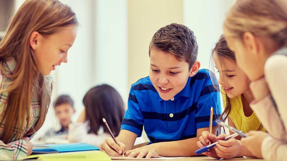 Gruppe von Schülern, die sich in der Schule unterhalten und schreiben