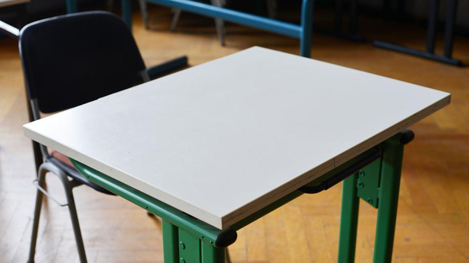 Leerer Schultisch im Klassenraum
