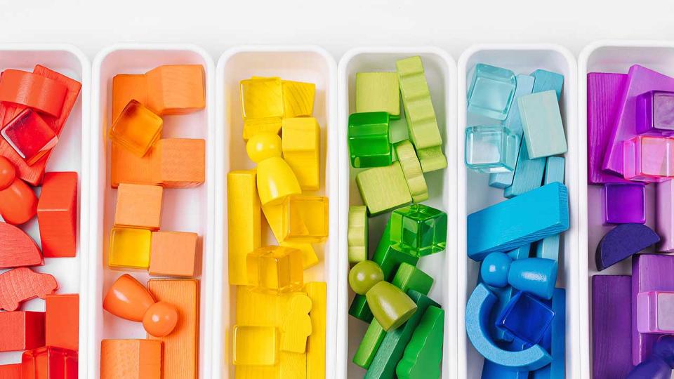 Lernspiele zum Sortieren von Farben. Rote, gelbe, grüne und blaue Holzklötze in Kisten. Farben Sortierspielzeug. Lernen durch Spielen. Montessori-Aktivitäten für Kleinkinder entwickeln.
