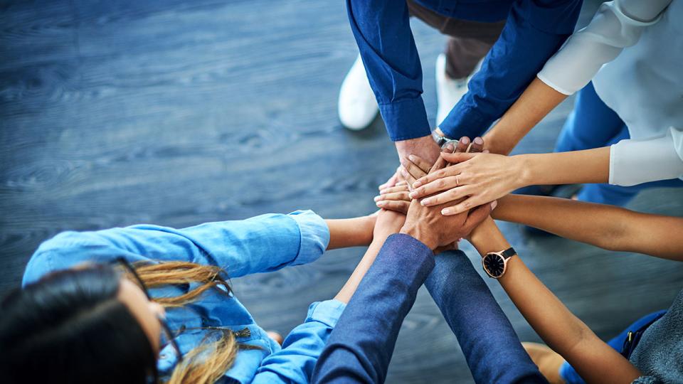 Kinder legen die Hände übereinander