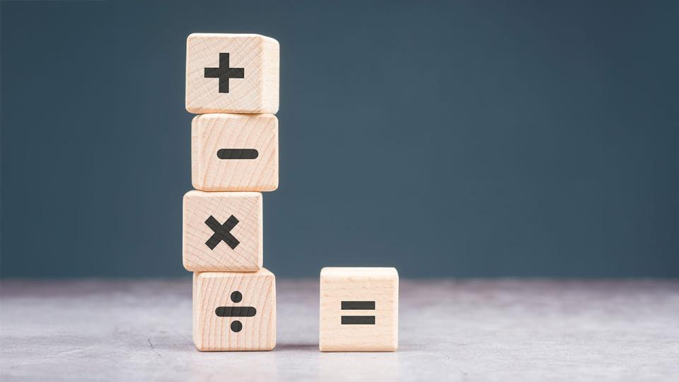 Mathematik-Operationszeichen auf Holzwürfeln, Plus, Minus, Multiplizieren, Dividieren und Gleichheitszeichen