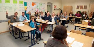Treffen von Vertreterinnen und Vertretern der Elternverbände in einem Klassenzimmer