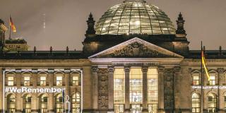 Deutscher Bundestag beleuchtet mit der Schrift "#We remember"
