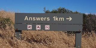 Straßenschild mit dem Hinweis, dass "answers" noch 1km entfernt sind