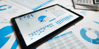 Büroarbeitsplatz für Unternehmen. Tablet-PC und Berichte. Tabelle Nahaufnahme.
