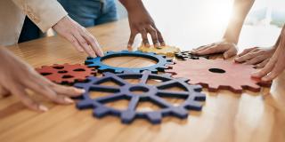 Hände, Zusammenarbeit und Ausrüstung mit einem Geschäftsteam, das in Synergie für Innovation in einem Workshop zusammenarbeitet. Treffen, Teamarbeit und Kreativität mit einer Gruppe von Männern und Frauen bei der Arbeit im Büro