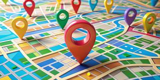 Ein stilisierter abstrakter Stadtplan mit einem einzelnen Marker-Pin, der leuchtende Farben und geometrische Formen zeigt