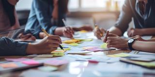 Geschäftsleute beim Brainstorming. Menschen verwenden Aufkleber, um ihre Ideen zu speichern. Planung eines Geschäftsprojekts. Das Konzept des Brainstormings in einem Start-up in einem Team.