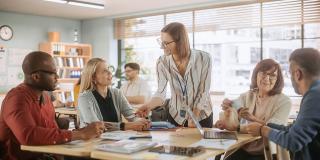 Vielfältige Gruppe junger und älterer Erwachsener, die eine Lösung für eine Teamaufgabe finden und an einem Trainingsprogramm zur Verbesserung der Fähigkeiten teilnehmen.