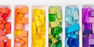 Lernspiele zum Sortieren von Farben. Rote, gelbe, grüne und blaue Holzklötze in Kisten. Farben Sortierspielzeug. Lernen durch Spielen. Montessori-Aktivitäten für Kleinkinder entwickeln.