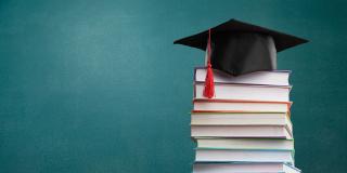 Bücherstapel mit Hut oben drauf