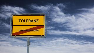 Ortseingangsschild mit der Aufschrift Toleranz, Diskriminierung durchgestrichen