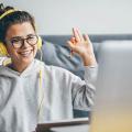 Frau mit Videoanruf auf ihrem Computer zu Hause. Lächelndes Mädchen studiert online mit Lehrer.