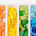 Lernspiele zum Sortieren von Farben. Rote, gelbe, grüne und blaue Holzklötze in Kisten. Farben Sortierspielzeug. Lernen durch Spielen. Montessori-Aktivitäten für Kleinkinder entwickeln.